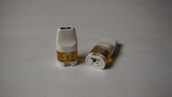 两颗同规格小烟弹并排摆放，底部卡口长度与凸起位置略有差异